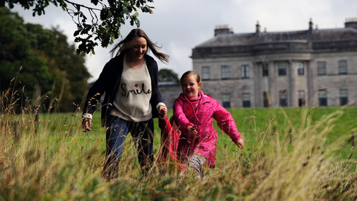 Visitors exploring the parkland at Castle Coole, County Fermanagh, Northern Ireland. Castle Coole is one of Ireland's finest Neo-classical houses, allowing visitors to glimpse what life was like in the home of the Earls of Belmore.